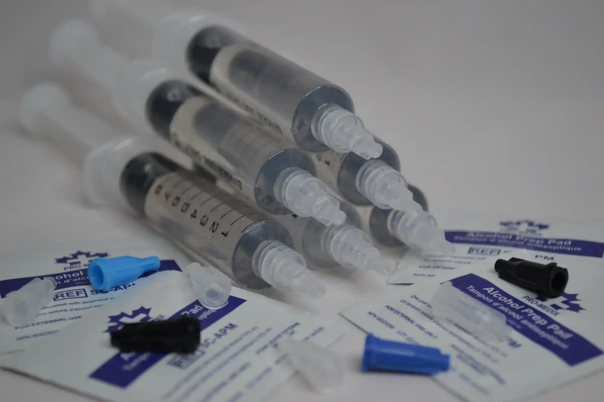 Several medical syringes arranged together with testing supplies.